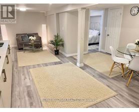 A living room with a couch, a chair, and a dining table.