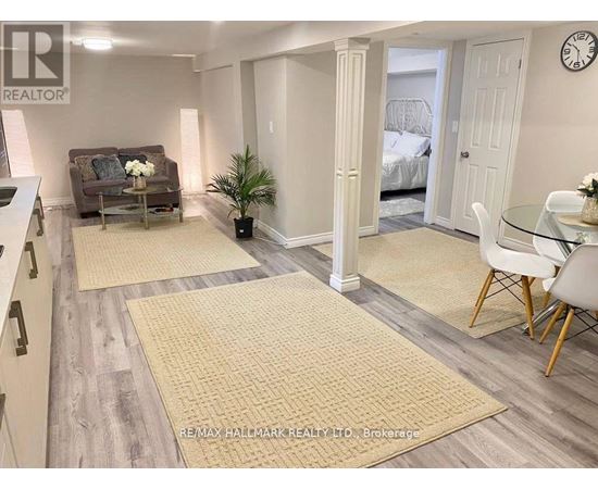A living room with a couch, a chair, and a dining table.