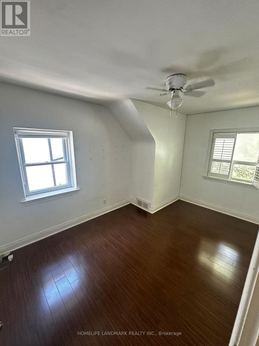 A room with wooden floors and a ceiling fan.