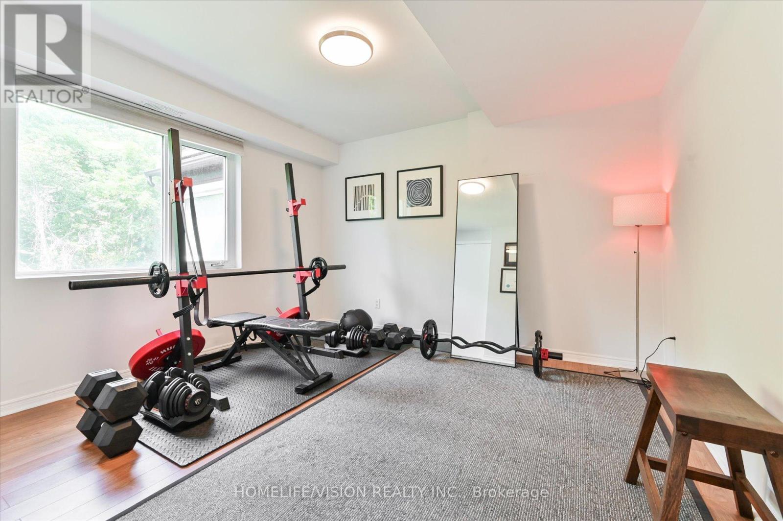 A home gym with a pull up bar, weights and a bench.