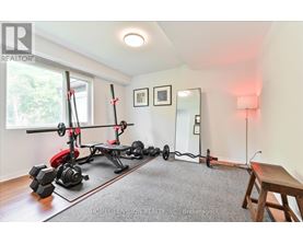 A home gym with a pull up bar, weights and a bench.