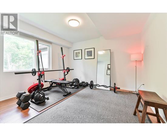 A home gym with a pull up bar, weights and a bench.