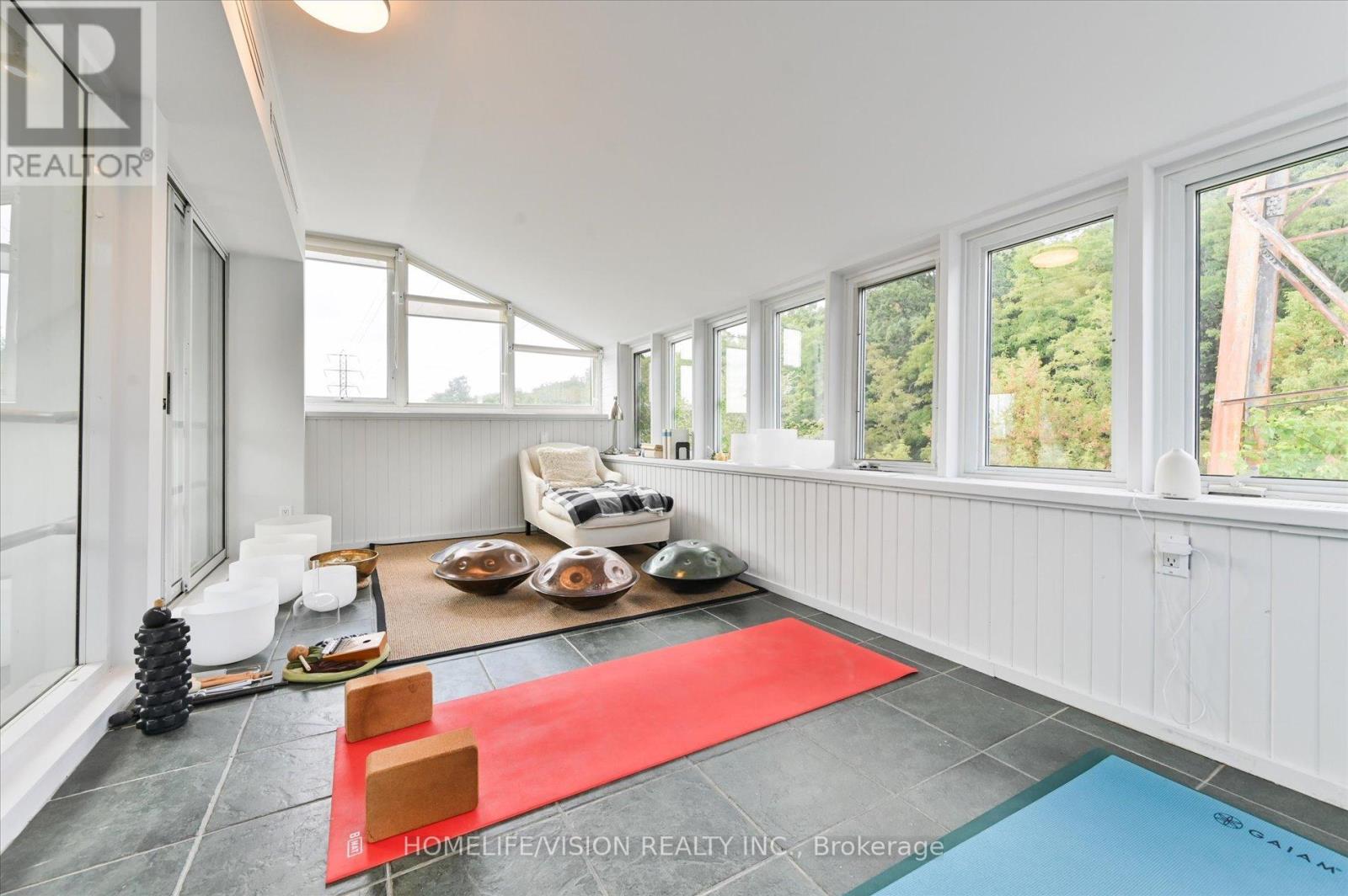 A bright room with a red rug and a pool table.