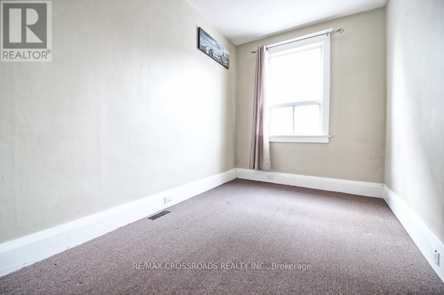 A room with a window and a carpet on the floor.