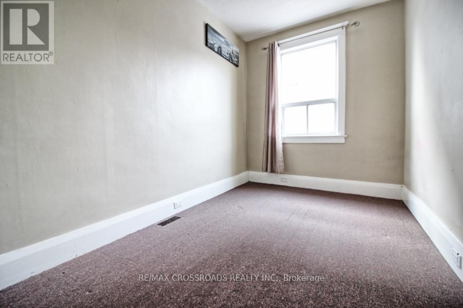 A room with a window and a carpeted floor.