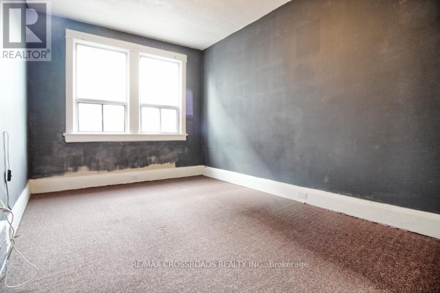 A room with a window and a carpeted floor.