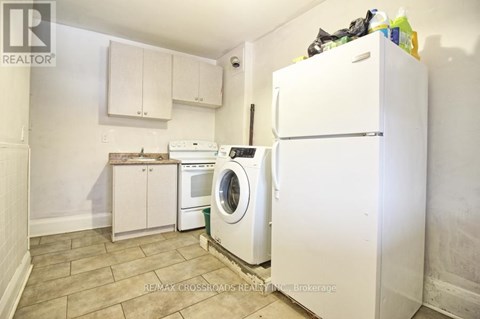 A small kitchen with a washing machine and a refrigerator.