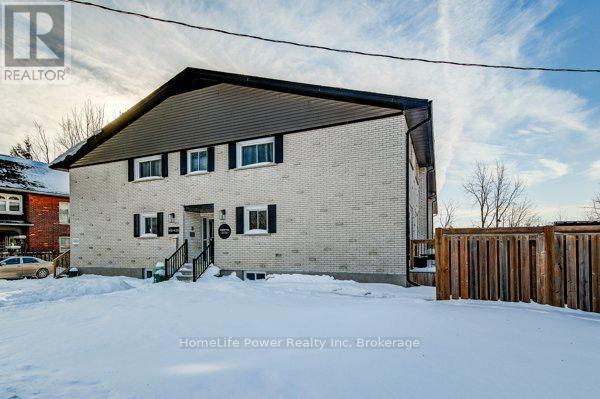 A house with a snowy front yard and a wooden fence.