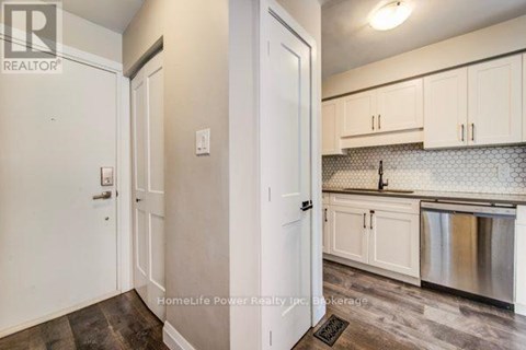 A kitchen with white cabinets and a stainless steel dishwasher.