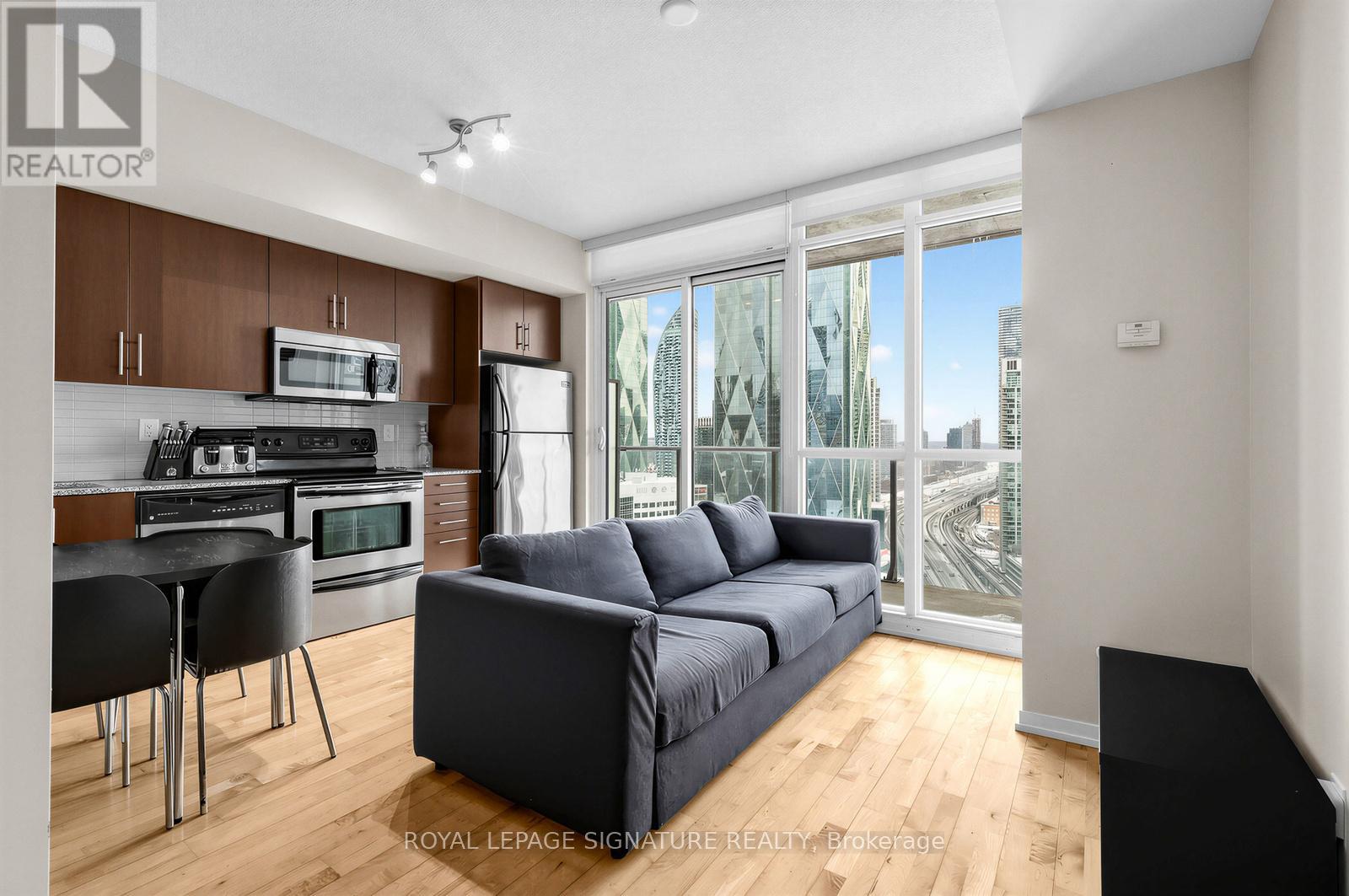 A modern kitchen with a dining table and a couch.