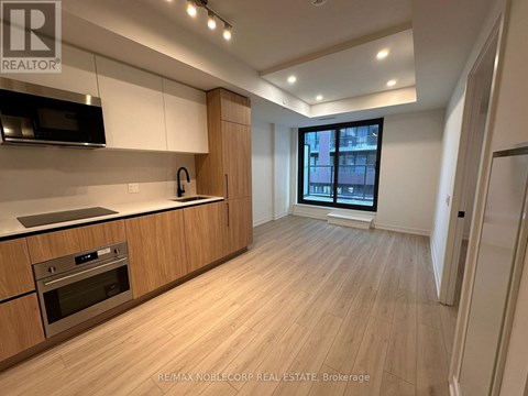 A modern kitchen with wooden cabinets and a stainless steel oven.