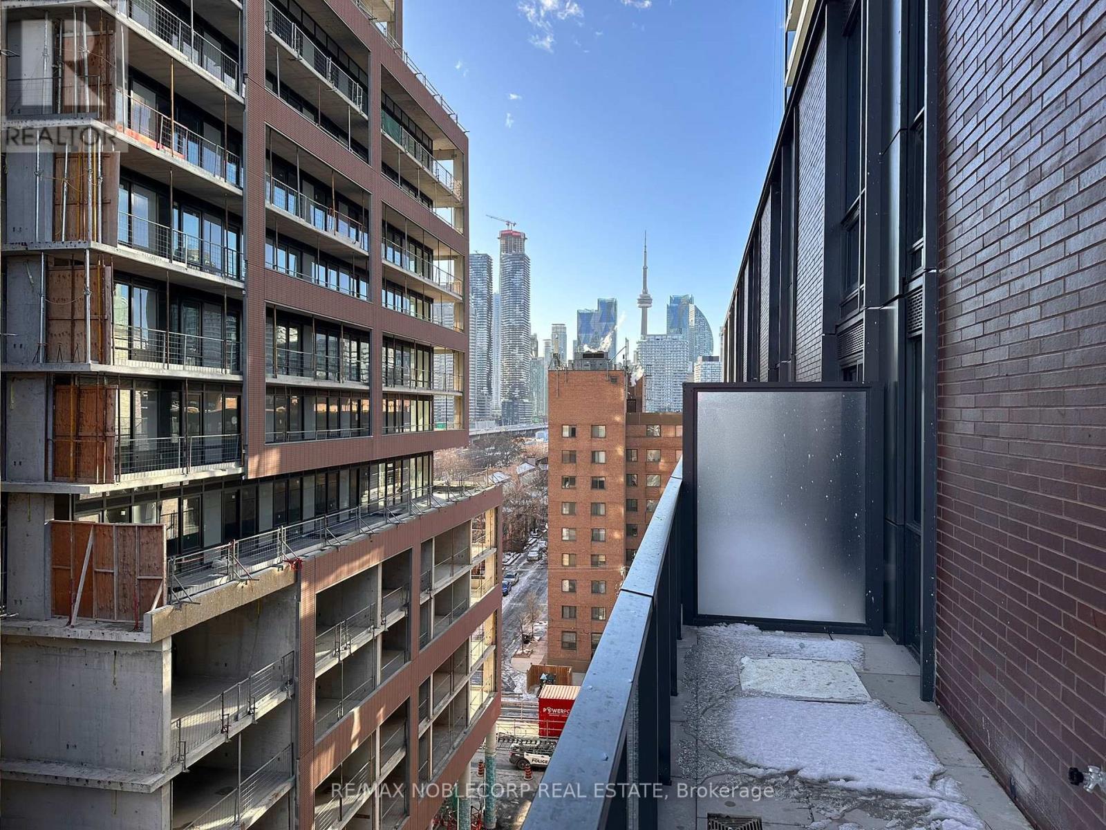 A view of a cityscape from a high-rise building with a balcony.