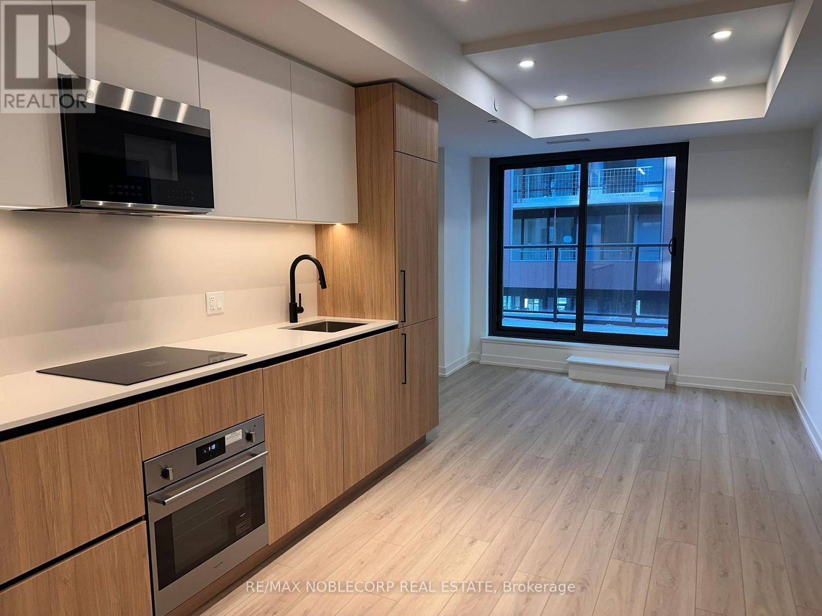 A modern kitchen with wooden cabinets and a stainless steel oven.