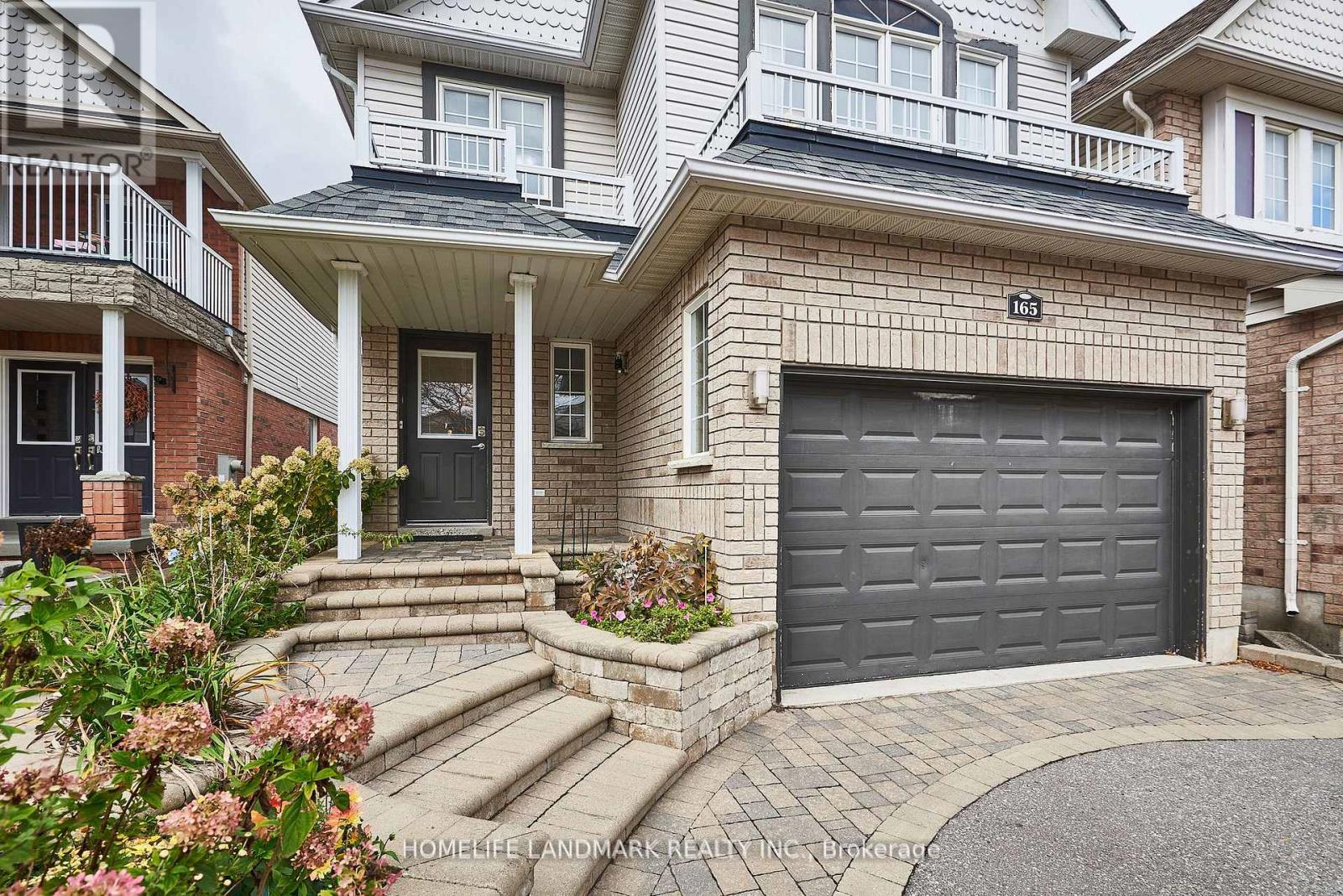 A two-story house with a garage door and a front porch.