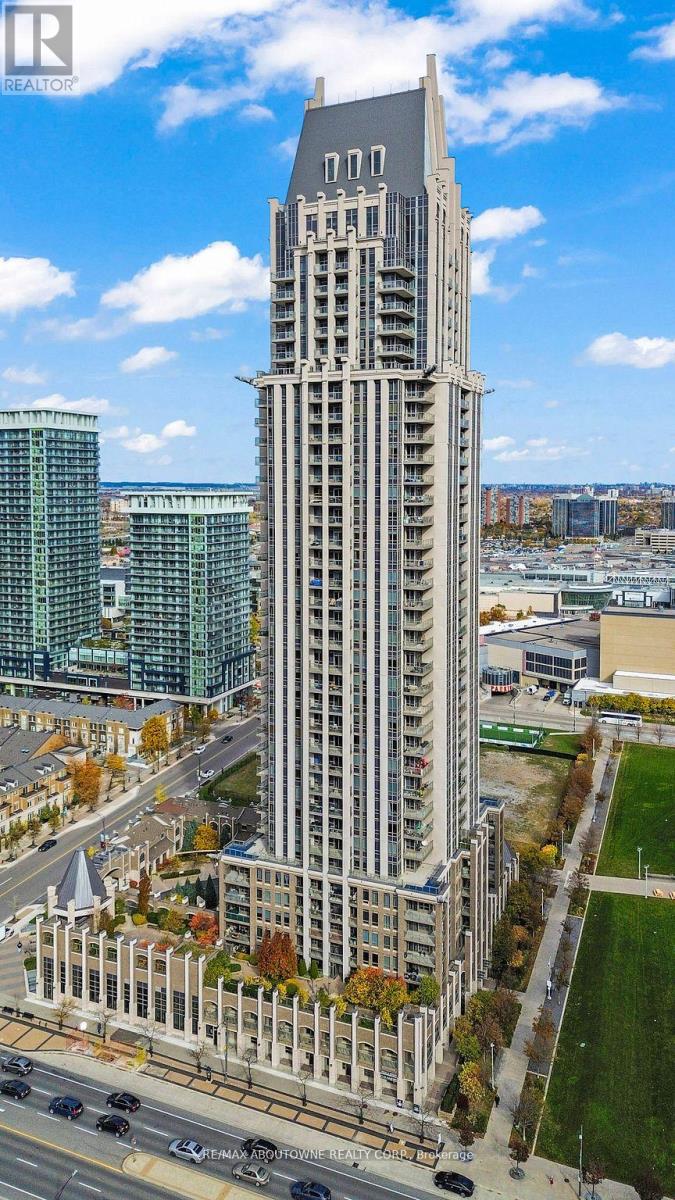 A tall building with a grey facade stands in the foreground of a cityscape.