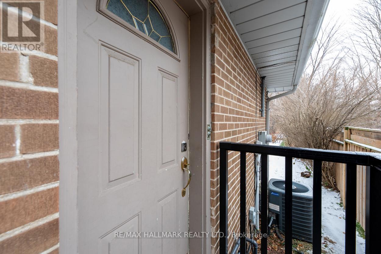 A white door with a gold handle is on the left and a black railing is on the right.