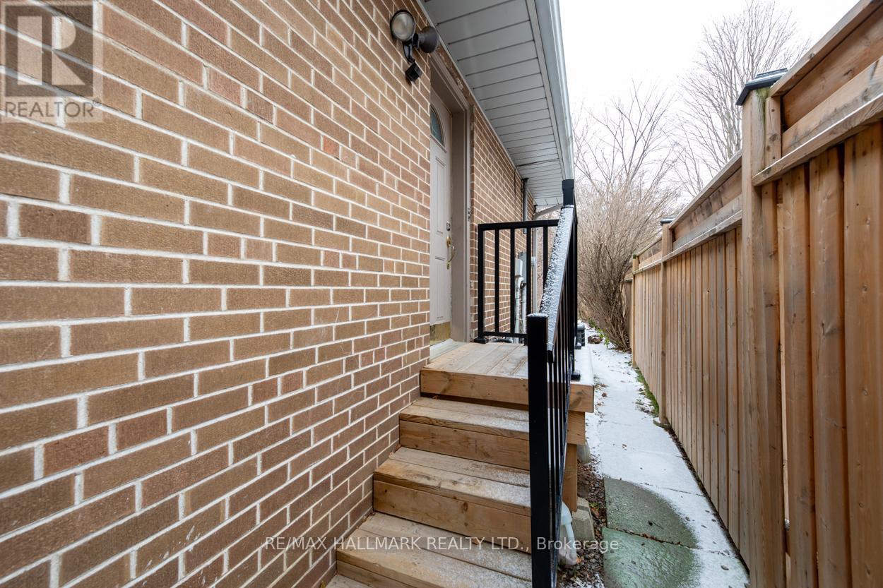 A brick wall with a black railing and steps leading up to it.