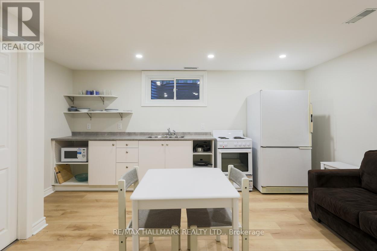 A kitchen with a table and chairs in the foreground and a refrigerator in the background.