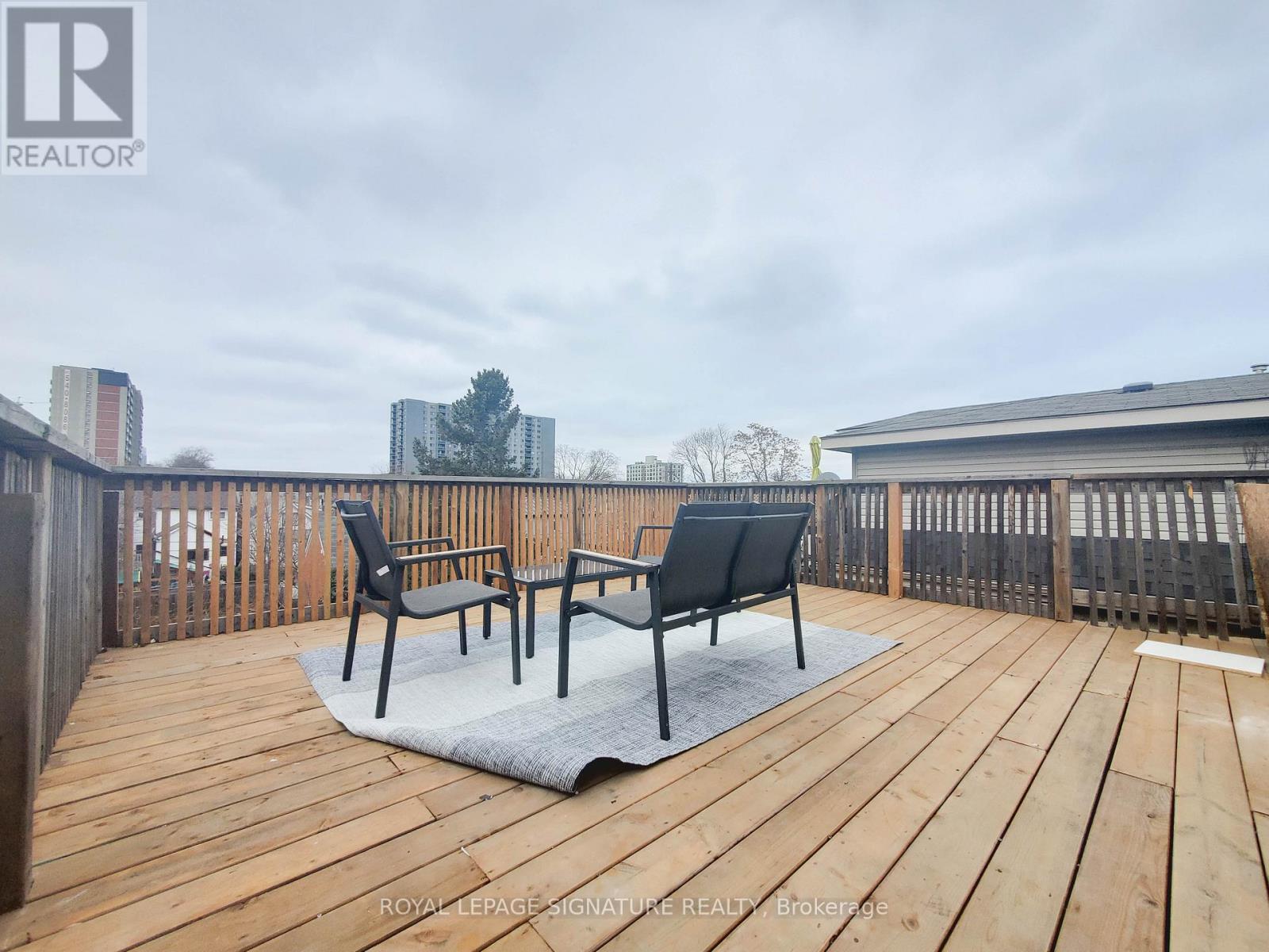 A wooden deck with two chairs and a table.