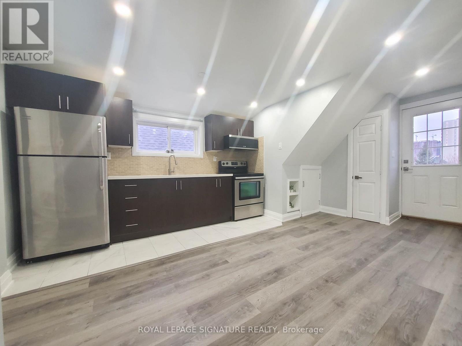 A spacious kitchen with a refrigerator, oven, and microwave.