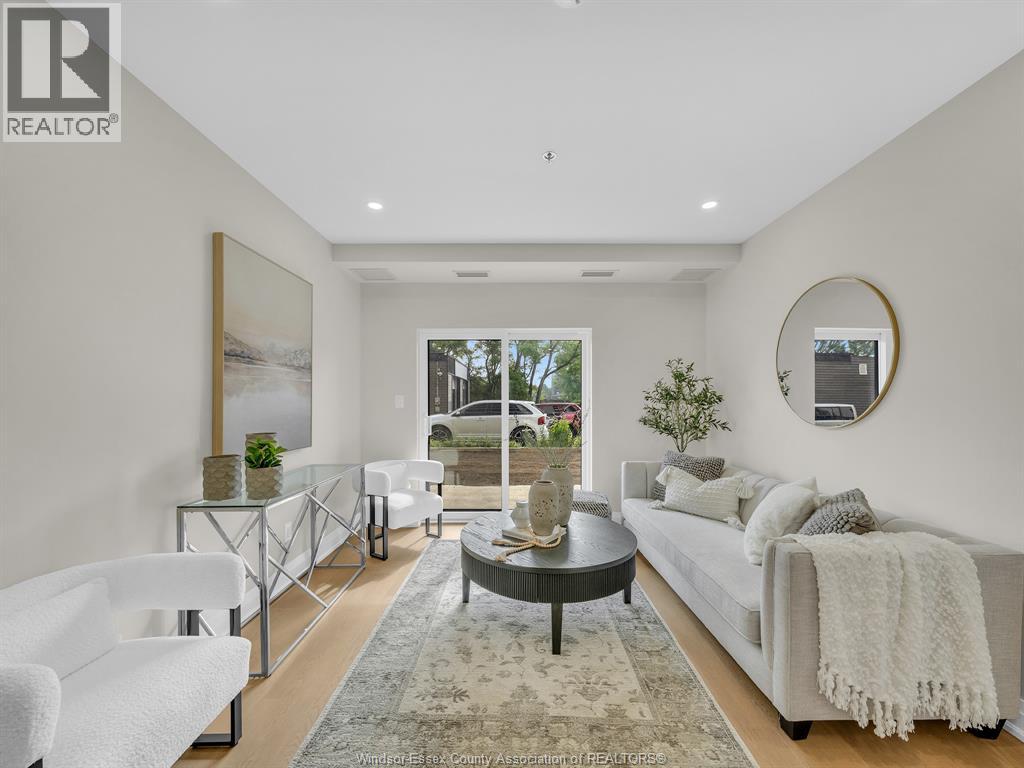 A modern living room with a glass coffee table and a large window.