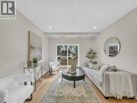 A modern living room with a glass coffee table and a large window.