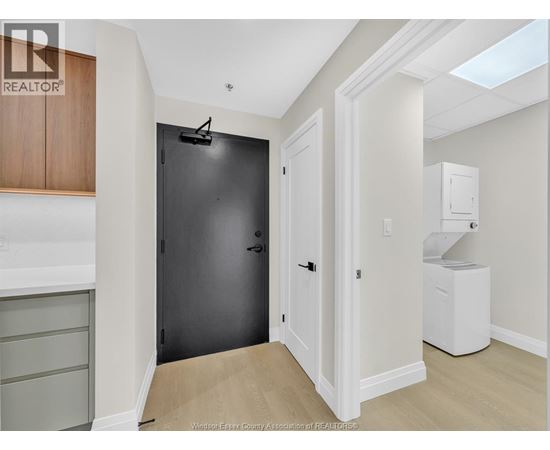 A black door is in a white hallway.