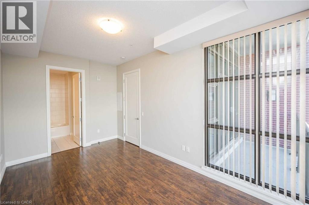 A spacious room with wooden floors and white walls.