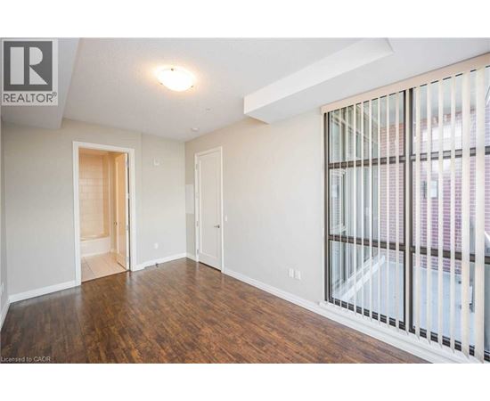 A spacious room with wooden floors and white walls.