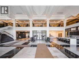 A large, open-concept living space with a marble floor and a central staircase.