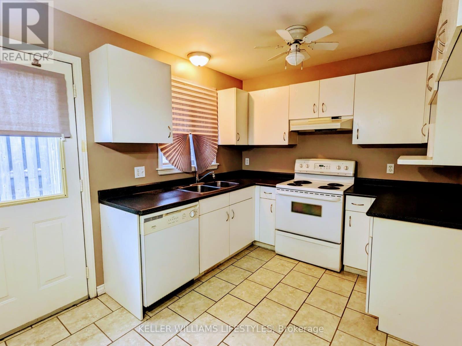 A kitchen with white appliances and cabinets.