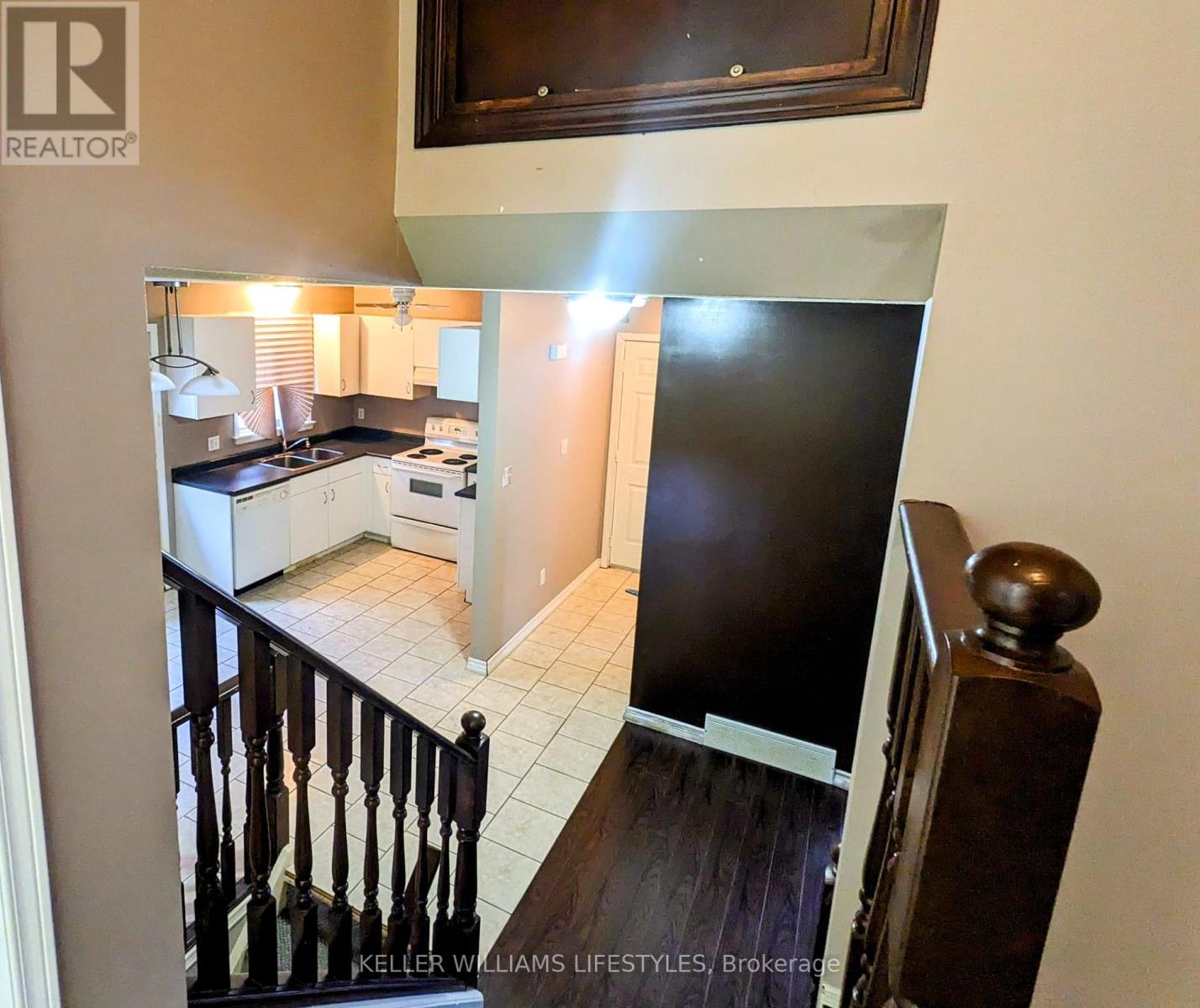 A kitchen with white appliances and a black refrigerator.