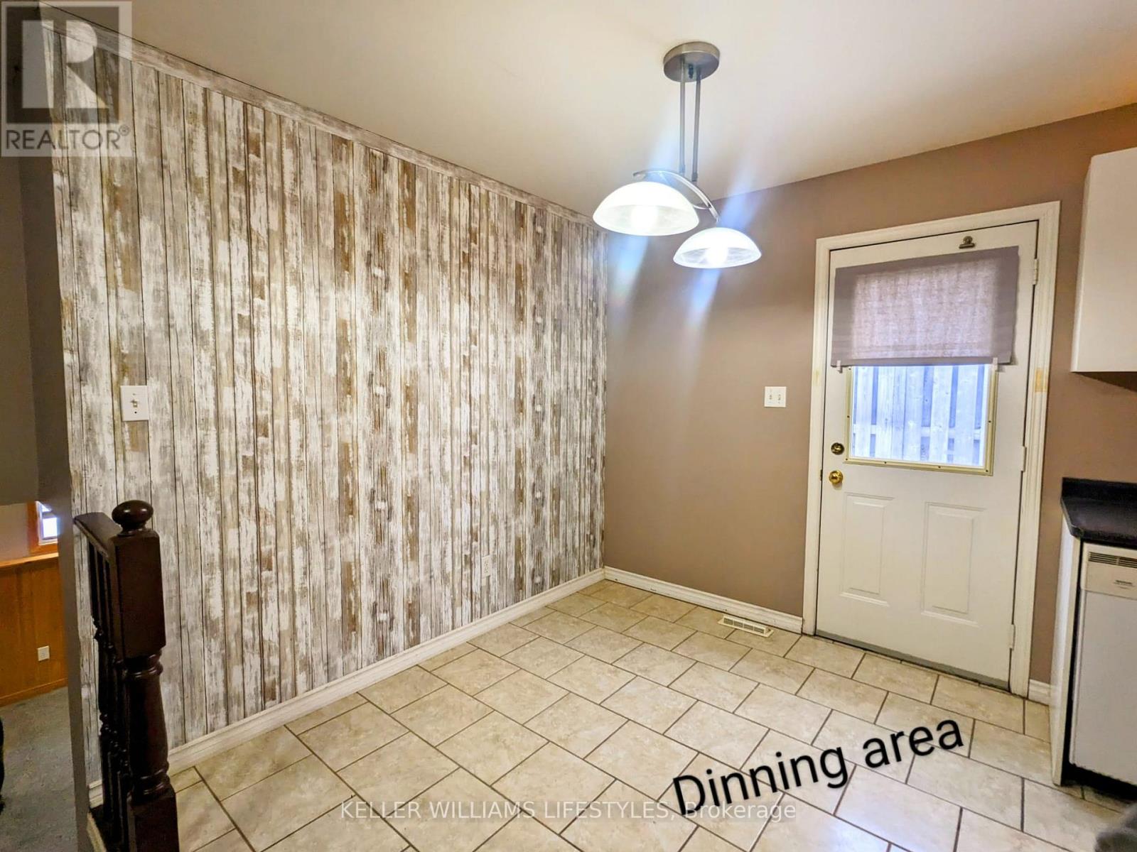 A dining area with a wooden floor and a wallpapered wall.