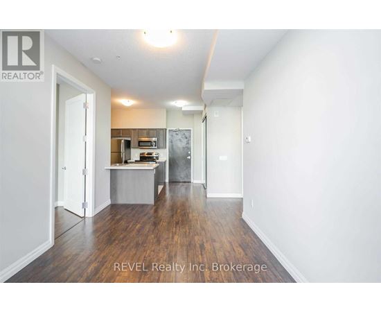 A room with a kitchenette and a refrigerator in it.