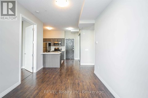 A room with a kitchenette and a refrigerator in it.