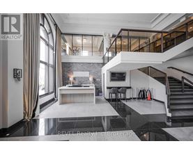 A modern living room with a staircase leading to the upper level.