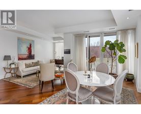 A dining room with a white table and chairs.