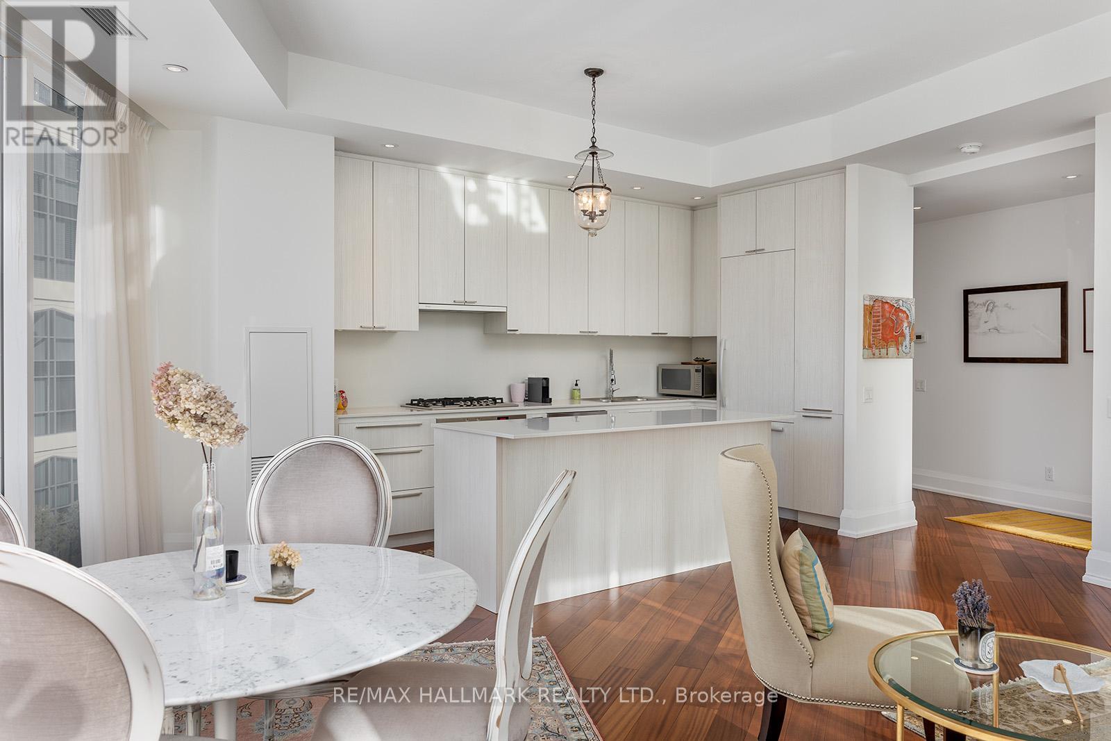 A modern kitchen with white cabinets and a dining table set with vases.