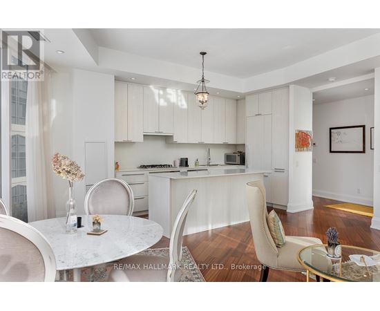 A modern kitchen with white cabinets and a dining table set with vases.