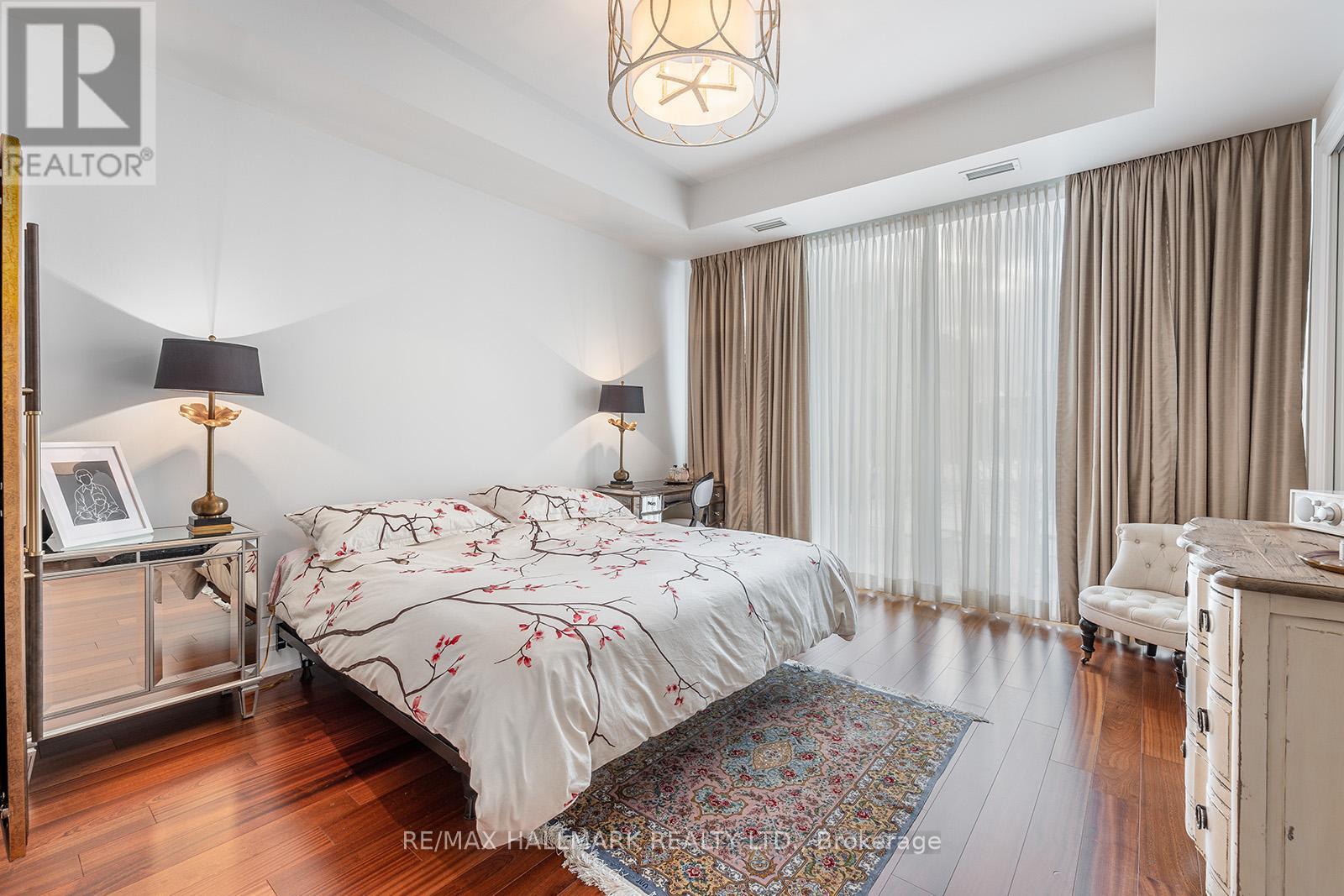 A bedroom with a large bed and a chandelier.