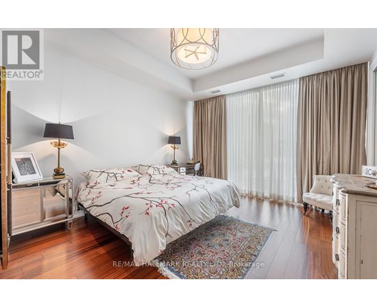 A bedroom with a large bed and a chandelier.
