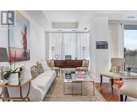 A living room with a white couch, a coffee table, and a painting on the wall.