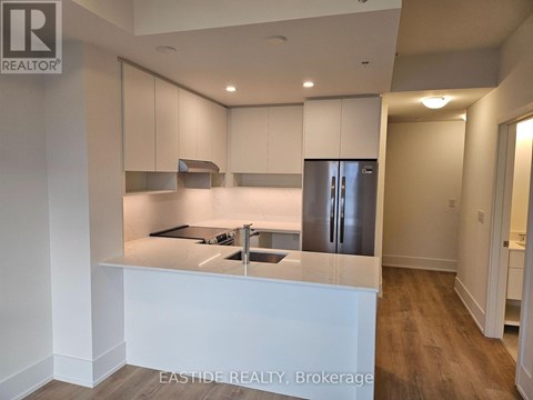 A kitchen with white cabinets and a refrigerator.