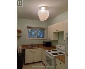 A kitchen with a stove, sink, and microwave.