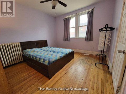 A bedroom with a bed, a ceiling fan, and a window.