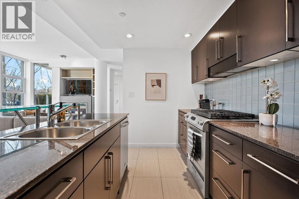 A modern kitchen with a dining table set for two.