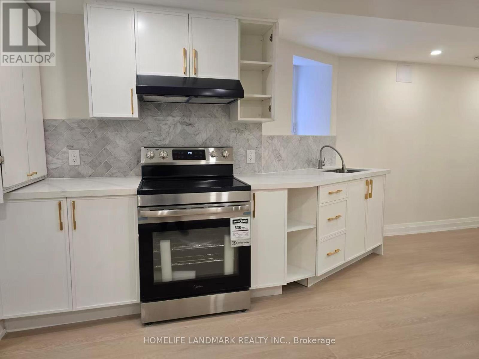 A modern kitchen with white cabinets and a stainless steel oven.
