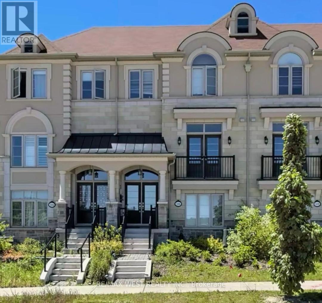 A large, two-story building with a balcony and a staircase leading to the entrance.