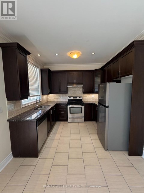 A kitchen with dark brown cabinets and a white refrigerator.