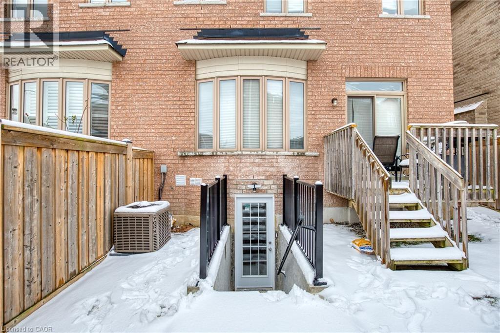 A red brick house with a wooden fence and a snow-covered ground.